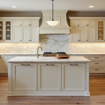 Elegant white shaker-style kitchen with marble countertops, large center island, custom cabinetry, and warm hardwood floors