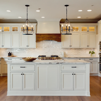 Luxury white modern farmhouse kitchen with marble island, pendant lighting, subway tile backsplash, and hardwood floors